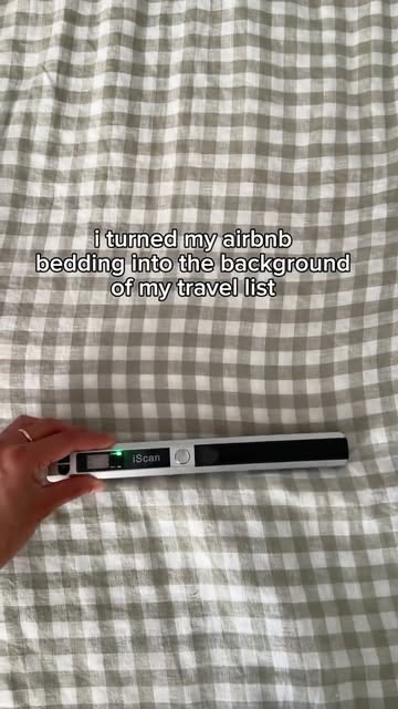 Handheld scanner on gingham bedding for a travel-list background